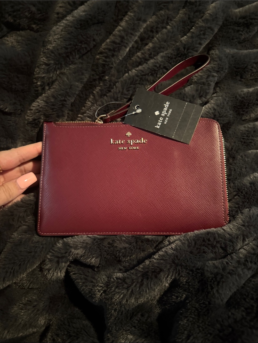kate spade wristlet in wine red with gold logo